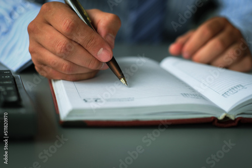 Businessman makes a note in notebook.