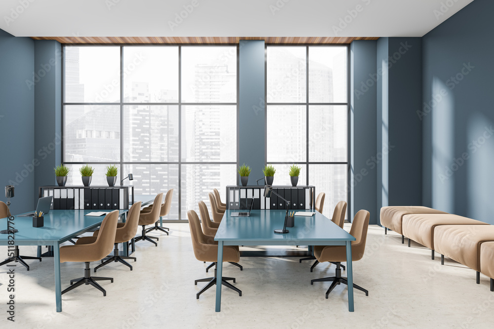 Fototapeta premium Workplace interior with laptop on desk, couch and panoramic window on city view