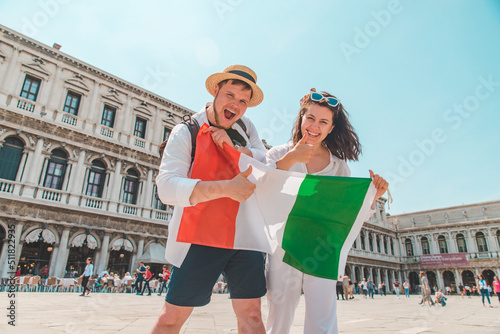 smiling couple holding italian flag venice central square san marco © phpetrunina14
