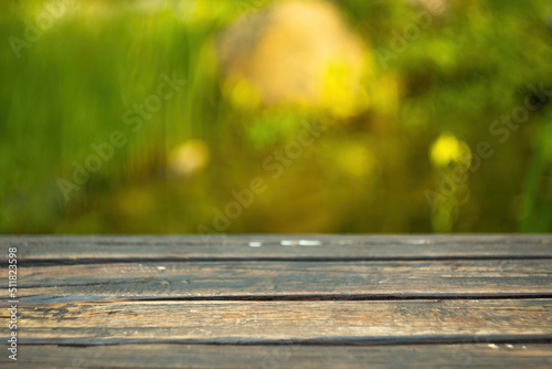 Blurred background of green park in summer, Wood table top on shiny bokeh green background. For product display