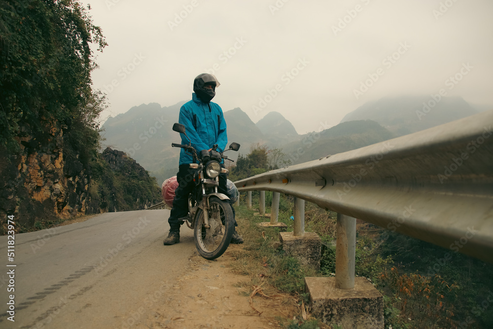 A tourist on a motorbike journey in the famous Ha giang Loop in North Vietnam A tourist on a motorbike journey in the famous Ha giang Loop in North Vietnam