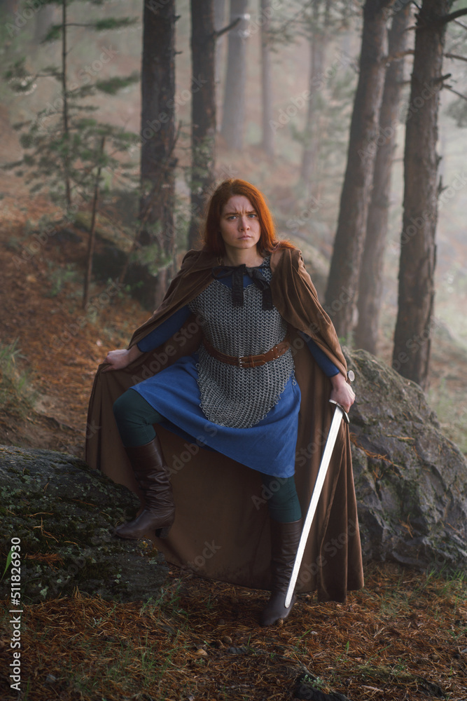 Portrait red-haired girl in armor and raincoat in forest