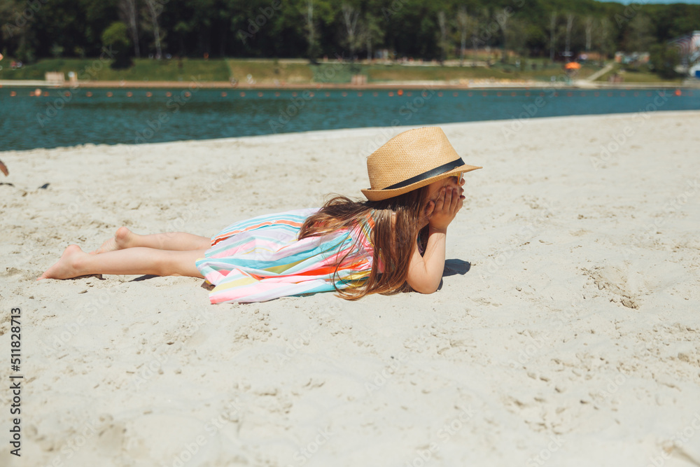 little girl child with down syndrome lies on the beach. normal life of ...