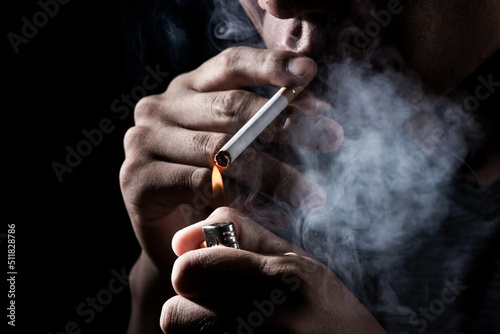 Fotografie close up of a man smok a cigarette on black background