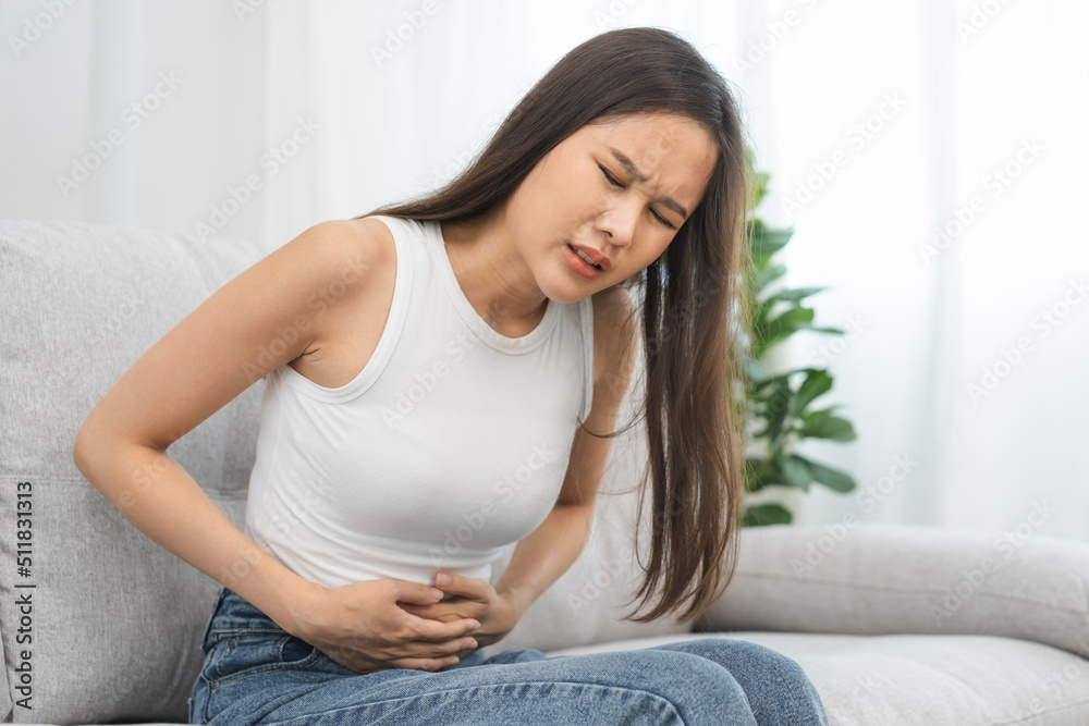 Flatulence asian young woman, girl hand in stomach ache, suffer from food poisoning, abdominal pain and colon problem, gastritis or diarrhoea. Patient belly, abdomen or inflammation, concept. Flatulence asian young woman, girl hand in stomach ache, suffer from food poisoning, abdominal pain and colon problem, gastritis or diarrhoea. Patient belly, abdomen or inflammation, concept.