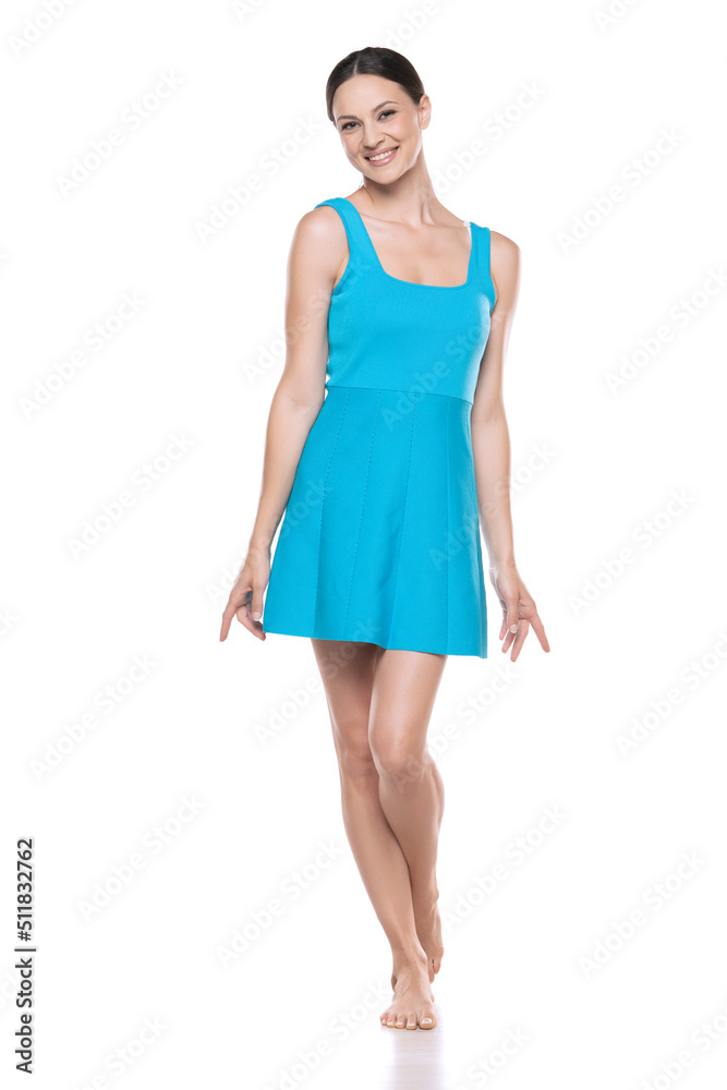 a young barefeet happy woman in a short blue dress posing on white background a young barefeet happy woman in a short blue dress posing on white background