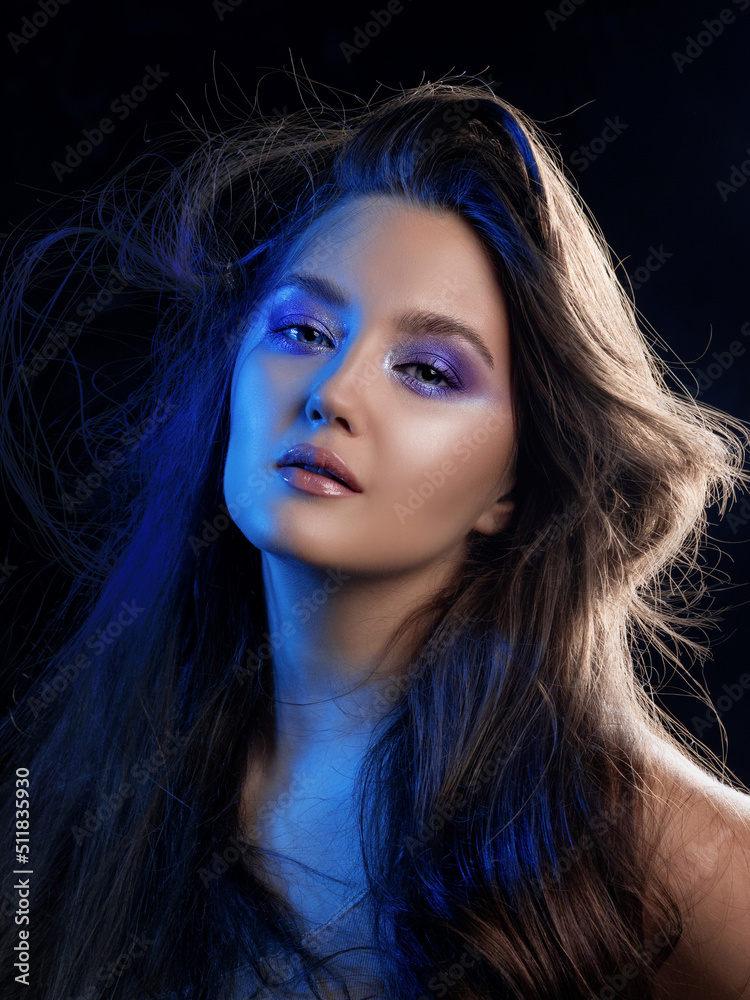 Obraz premium Gorgeous brunette with long beautiful hair. Bright makeup, shining eye shadow. Beautiful styling and makeup, glamorous diva