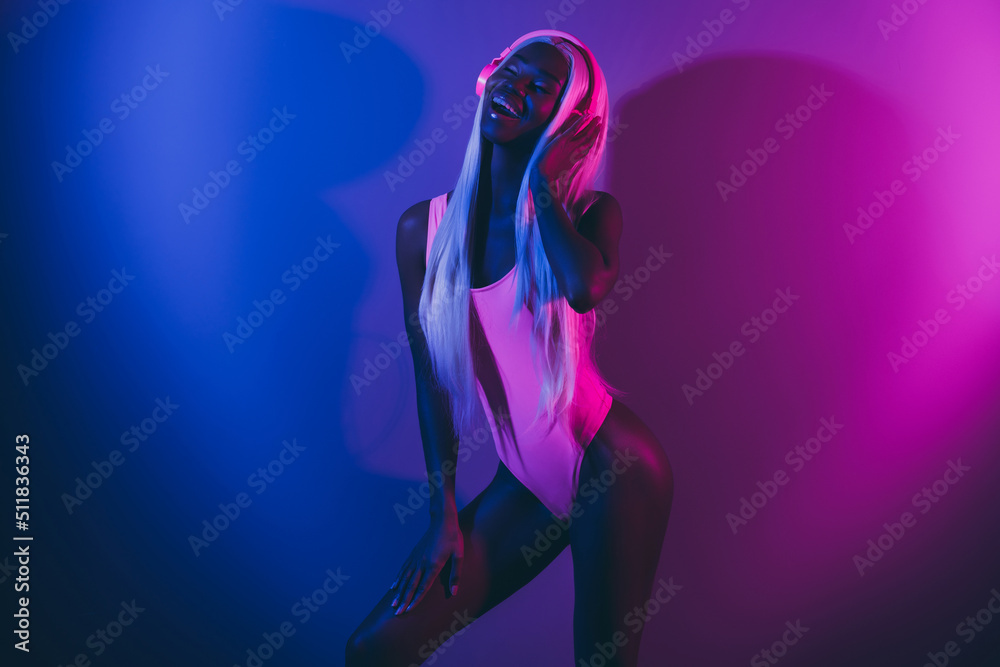 Sensual photo of young trendy lady relaxing on party listen hip hop in headset isolated on pink blue vivid background