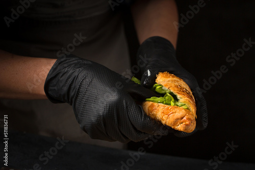 The chef puts arugula in a croissant