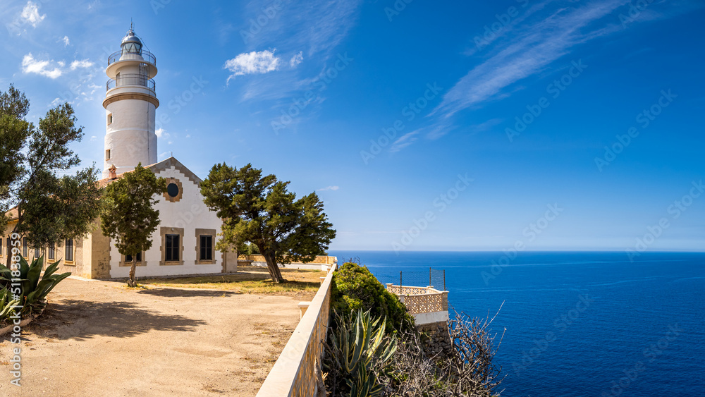 Front view of the forecourt of historic Puerto de Soller lighthouse called Far del Cap Gros sunlit in summer with copyspace at the right side and the mediterranean sea in the background at Mallorca. - obrazy, fototapety, plakaty 