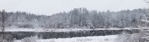 Winter landscape, Christmas and New Year. Snow-covered trees are reflected in the forest river