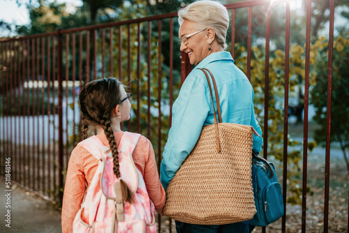 Grandmother taking her granddaughter to school.