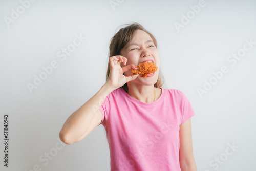 Young asian woman holding and eating fries chicken on white background