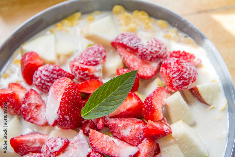 Cornflakes with oat milk and fruit - apple, pear and strawberries decorated with mint leaf Cornflakes with oat milk and fruit - apple, pear and strawberries decorated with mint leaf