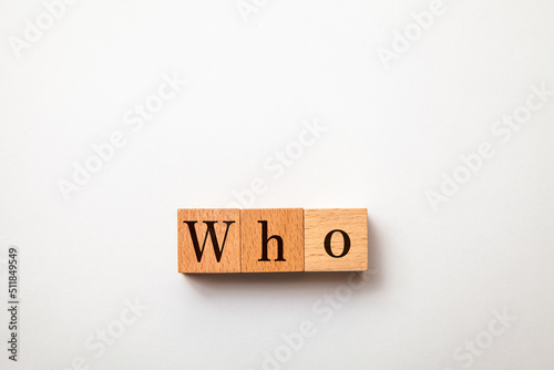 Whoの文字。誰が。疑問代名詞。3つの木製ブロックに書かれている。黒い文字。白い背景。