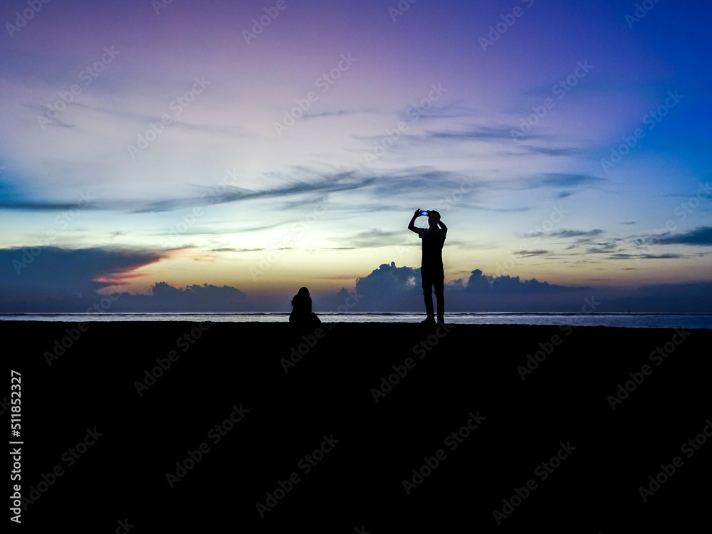 Sunrise silhouette couple taking pictures