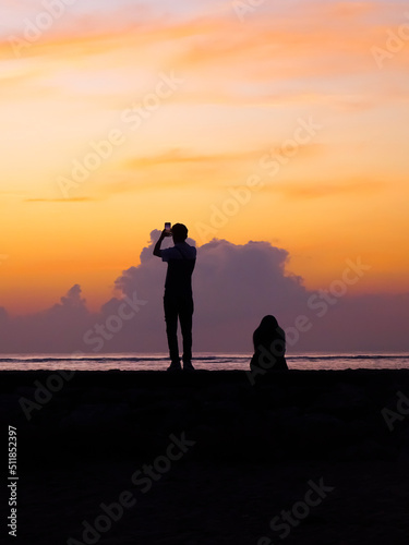 Sunrise silhouette couple taking pictures