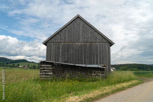 Mountains And Old Wooden Barn In The Field
