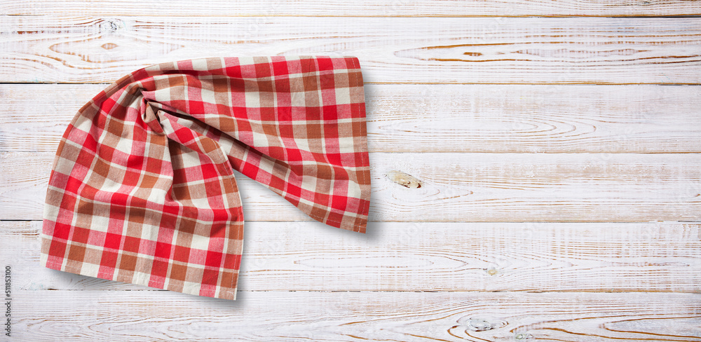 Fototapeta premium Towel or tablecloth, napkin, rough fabric texture with creased folds on wooden desk top view.