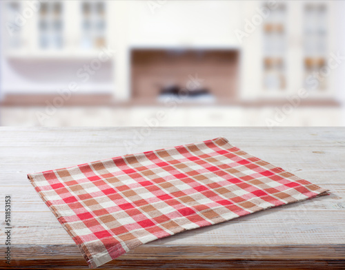 Folded towel, linen tablecloth on wooden desk perspective. Kitchen interiors bacground. Selective focus.