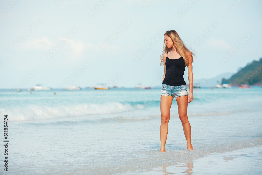 Young attractive blonde girl with perfect sport body in bikini on the tropical summer beach Young attractive blonde girl with perfect sport body in bikini on the tropical summer beach