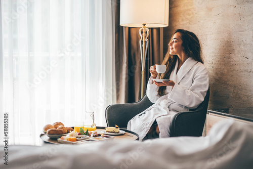 Murais de parede Woman eating breakfast in the hotel room