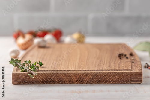 square wooden cutting board with edging. cherry tomatoes and spices on a white background. mockup with copy space for text  side view