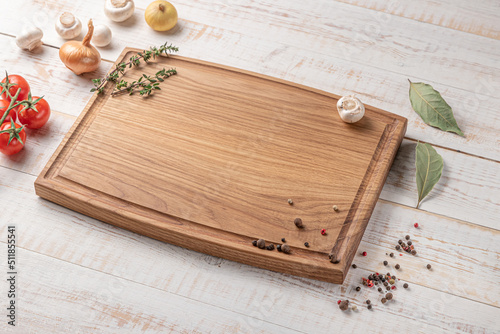 square wooden cutting board with edging. cherry tomatoes and spices on a white background. mockup with copy space for text, side view