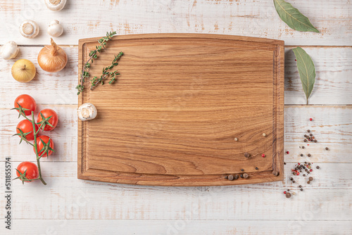 square wooden cutting board with edging. cherry tomatoes and spices on a white background. mockup with copy space for text, top view