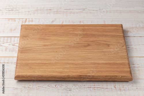 rectangular cutting board on a white wooden table. mockup of a food background with copy space, side view