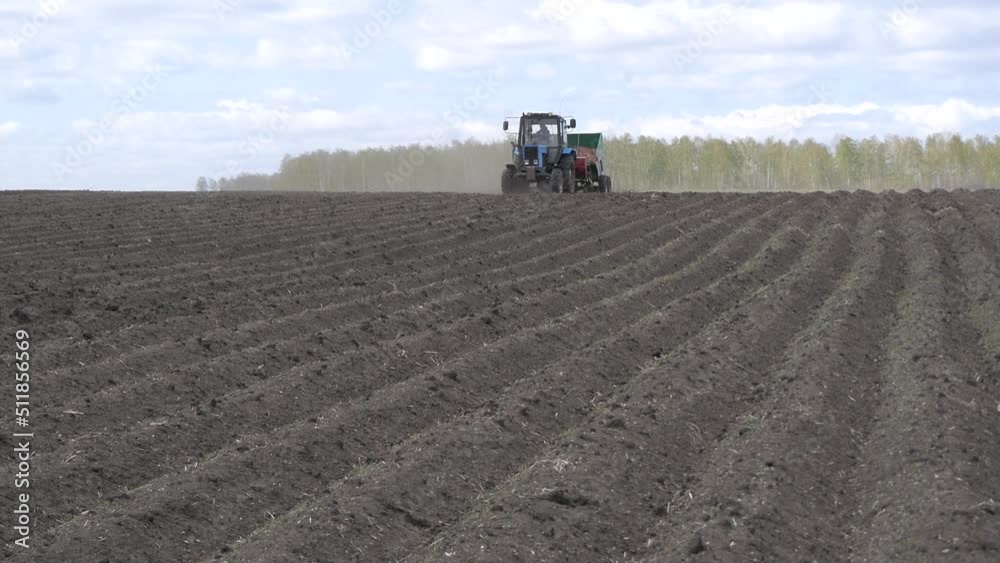Tractor at planting work in the field. Agricultural machinery for sowing potatoes. Tractor at planting work in the field. Agricultural machinery for sowing potatoes.