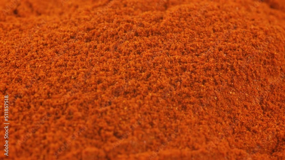 Ground red paprika spice turning. Closeup shot. Shallow depth of field.