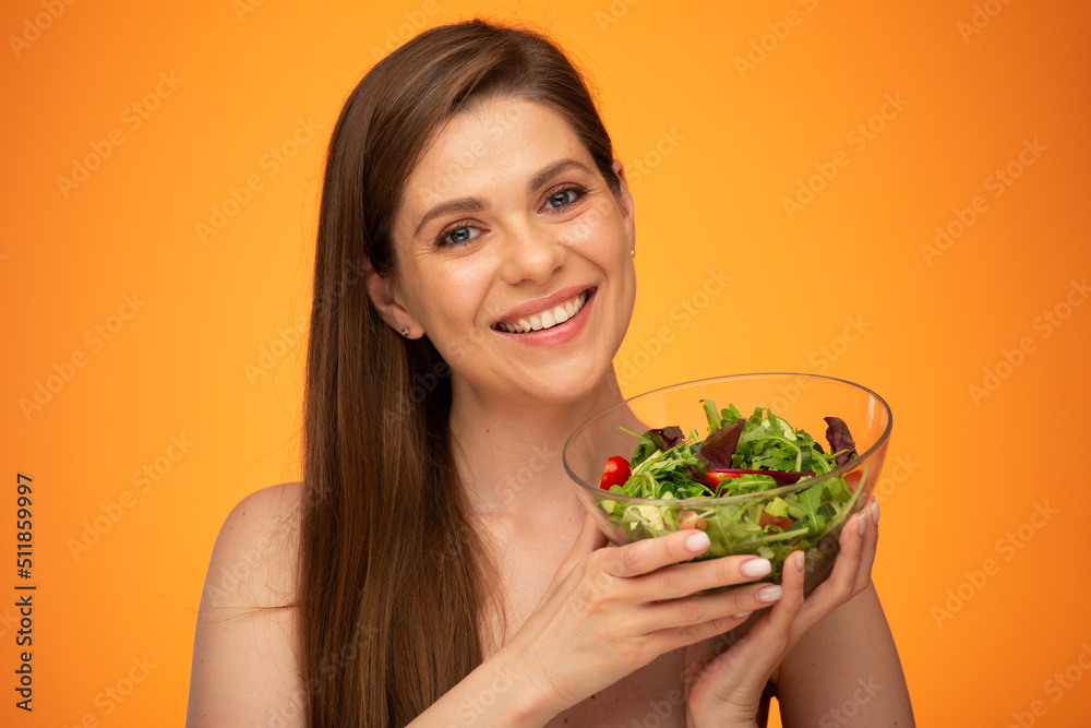 Happy laughing woman with bare shoulders holding green salad isolated portrait. Girl with long hair. Happy laughing woman with bare shoulders holding green salad isolated portrait. Girl with long hair.