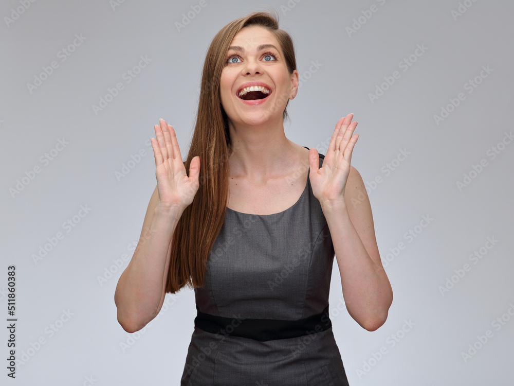 Happy woman in gray business dress standing with her hands up, isolated female portrait. Happy woman in gray business dress standing with her hands up, isolated female portrait.