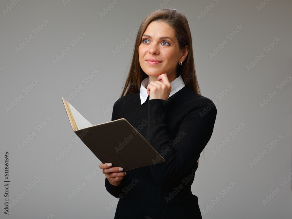 Smiling woman teacher or student in black business suit with white collar and long hair holding open book and looking away, isolated portrait of businesswoman. Smiling woman teacher or student in black business suit with white collar and long hair holding open book and looking away, isolated portrait of businesswoman.