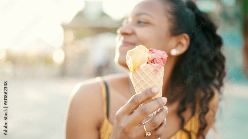 Closeup portrait of smiling woman with long curly hair with ice cream in her hands on an urban city background. Frontal close-up of a happy girl testing ice cream on a warm sunny day Closeup portrait of smiling woman with long curly hair with ice cream in her hands on an urban city background. Frontal close-up of a happy girl testing ice cream on a warm sunny day