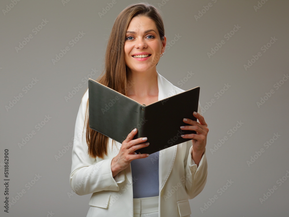 Smiling woman holding open book and looking at camera, woman in white suit studio isolated portrait. Smiling woman holding open book and looking at camera, woman in white suit studio isolated portrait.