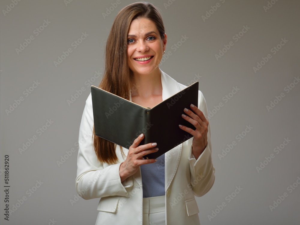 Smiling woman holding open book and looking at camera, woman in white suit studio isolated portrait. Smiling woman holding open book and looking at camera, woman in white suit studio isolated portrait.