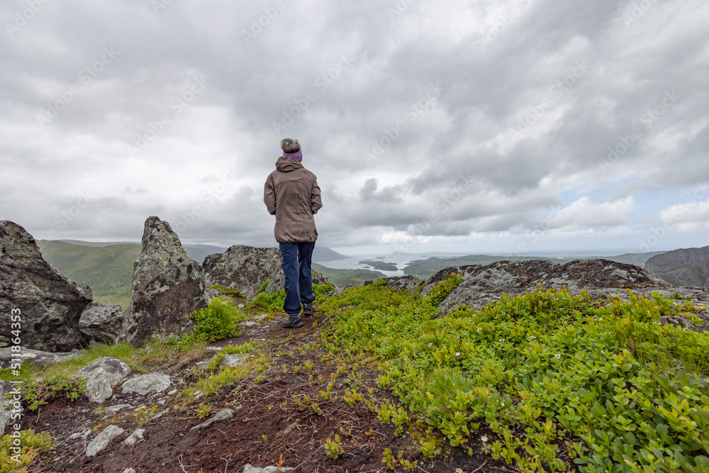 Obraz premium Happy woman hike to the mountains Gaasheituva, Northern Norway- Europe