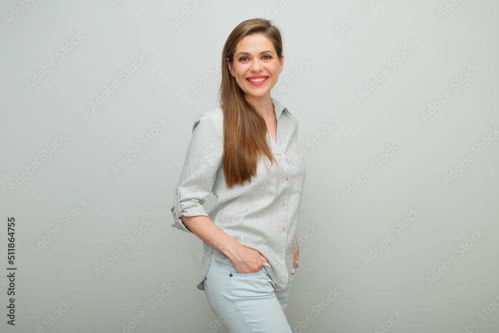 Smiling woman standing with hand in pocket, isolated female portrait, young lady dressed pants and gray shirt. Smiling woman standing with hand in pocket, isolated female portrait, young lady dressed pants and gray shirt.