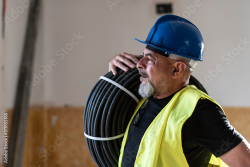 Construction worker poses with corrugated pipe destined for the electrical installation of a home
