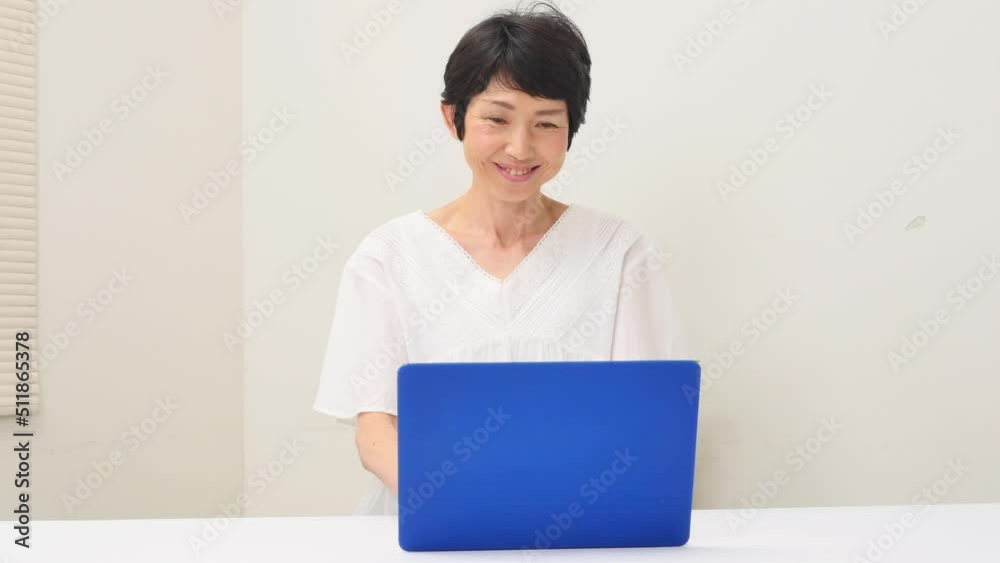 リビングでノートパソコンを使う中年女性