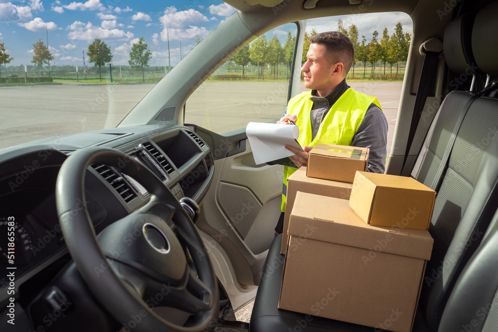 courier man near car. Courier man opens door to minivan. Boxes on seats of minivan. Courier man while doing work. Delivery service employee. Postman looks into minivan. Postal worker career courier man near car. Courier man opens door to minivan. Boxes on seats of minivan. Courier man while doing work. Delivery service employee. Postman looks into minivan. Postal worker career