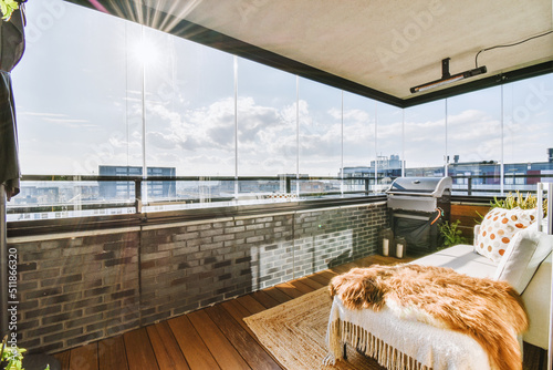 Fotografia A balcony of a house with glass walls and stylish furniture