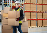 Bonded warehouse. Woman customs officer. Concept checking cargo at state border. Customs officer with boxes. Woman in protective helmet carries parcels. Distribution warehouse. Work at customs