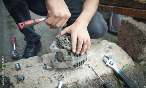 Man repairs car alternator. Technology. Industry