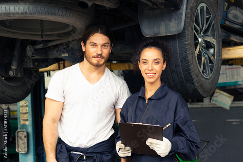 Multiracial mechanics at garage smiling at camera. Car inspection and maintenance concept.
