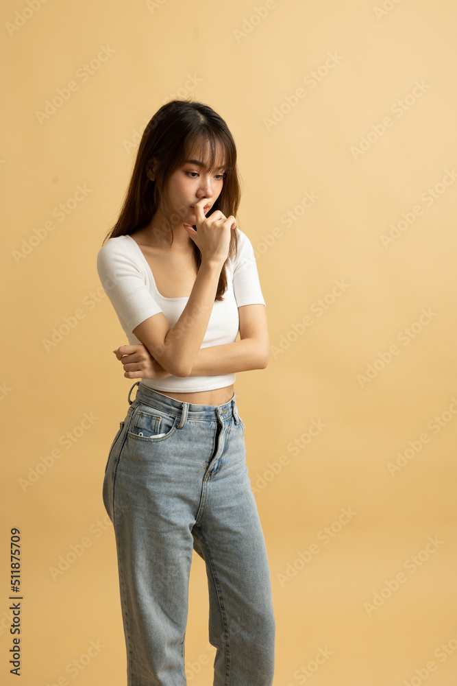 Young Asian girl dress in white shirt and jeans ready to travel on vacation on yellow isolated background Young Asian girl dress in white shirt and jeans ready to travel on vacation on yellow isolated background