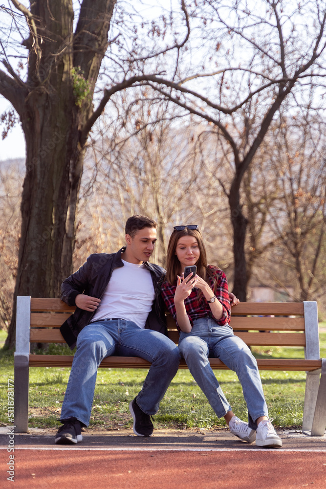 Looking on the phone while sitting on the bench Looking on the phone while sitting on the bench