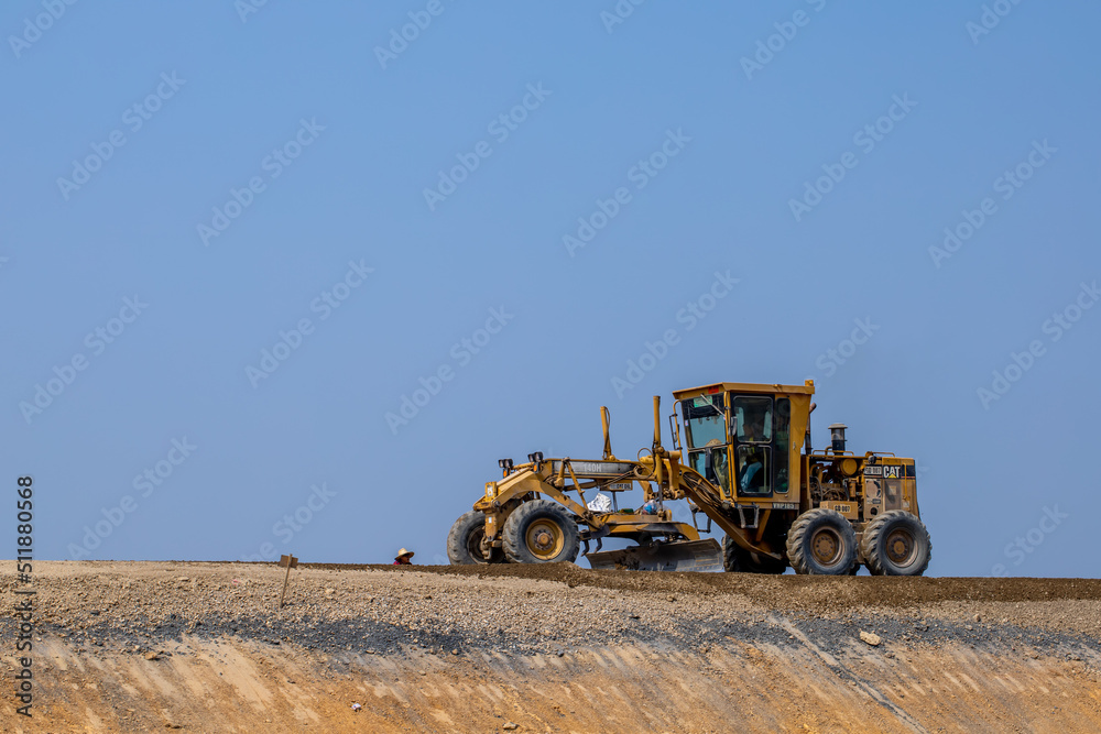The truck backhoe is working in the site with the light blue sky background. The truck backhoe is working in the site with the light blue sky background.
